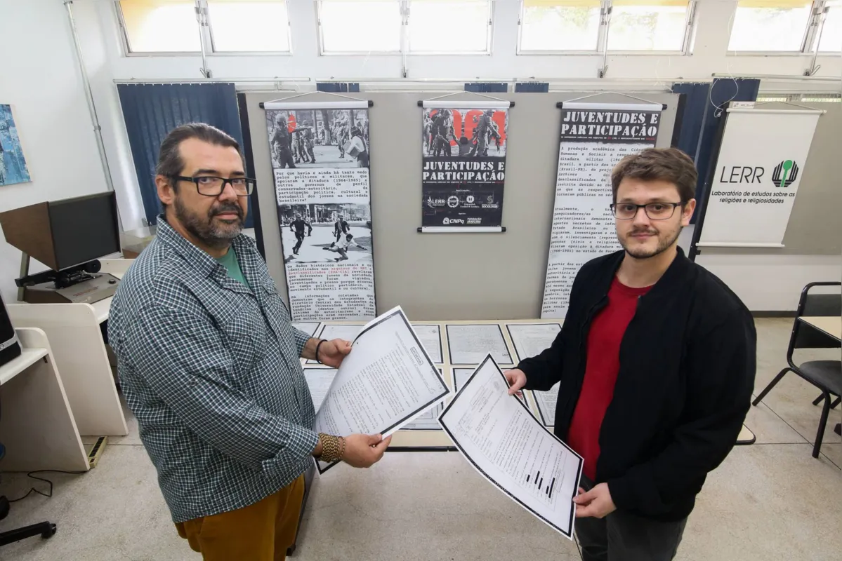 O professor Fábio Lanza e o pesquisador José Neves Junior, com parte dos documentos do projeto
