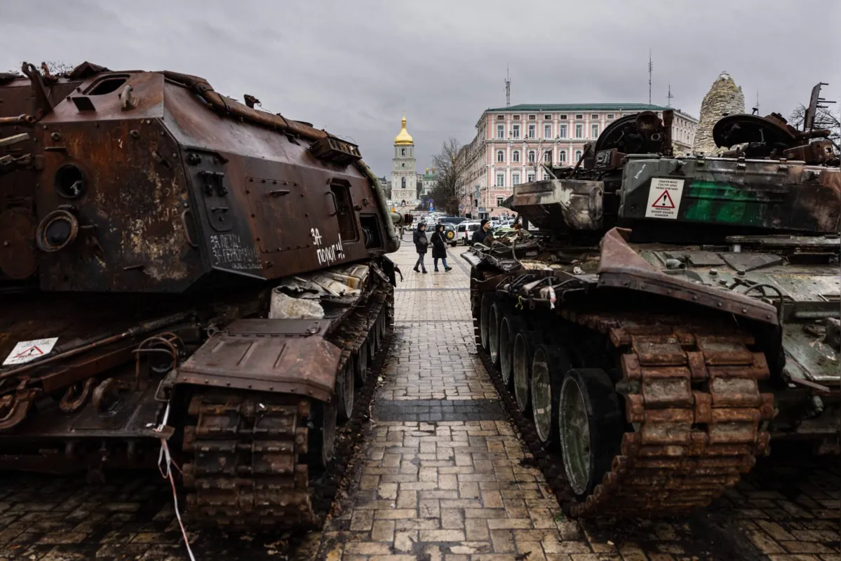 Pedestres olham para os veículos militares russos destruídos em uma exposição ao ar livre de equipamentos russos destruídos em Kyiv, em 5 de janeiro de 2023.