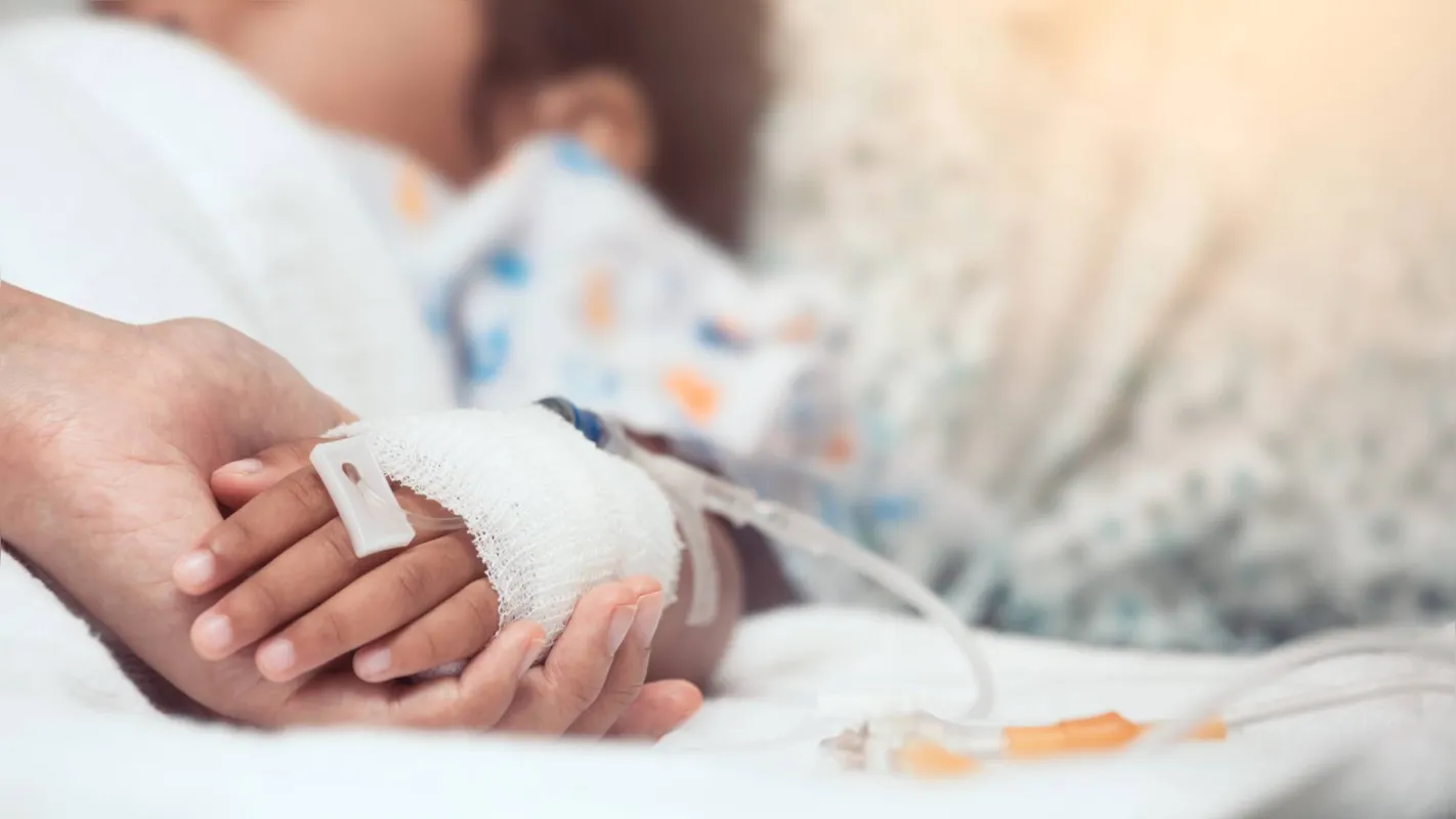 Mother hand holding child hand who have IV solution in the hospital with love and care