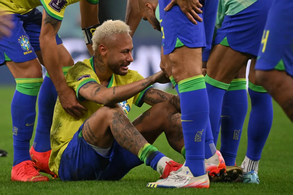Brazil's forward #10 Neymar is consoled by teammates after they lost the Qatar 2022 World Cup quarter-final football match between Croatia and Brazil at Education City Stadium in Al-Rayyan, west of Doha, on December 9, 2022. (Photo by NELSON ALMEIDA / AFP)