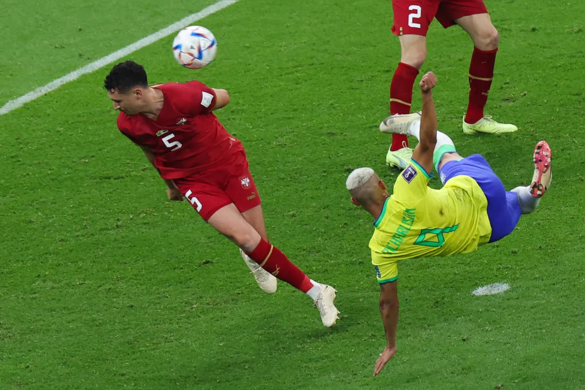Brazil's forward #09 Richarlison strikes the ball next to Serbia's defender #05 Milos Veljkovic to score his team's second goal during the Qatar 2022 World Cup Group G football match between Brazil and Serbia at the Lusail Stadium in Lusail, north of Doha on November 24, 2022. (Photo by Giuseppe CACACE / AFP)