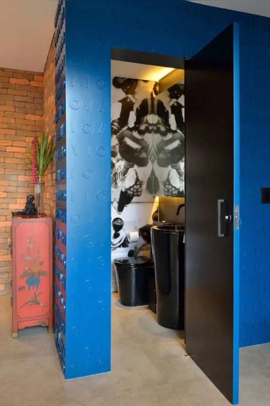 Apesar de não existir na planta original, o lavabo se tornou um dos destaques deste projeto – ele foi executado com um portal em laca azul, com desenhos em relevo, cheio de personalidade