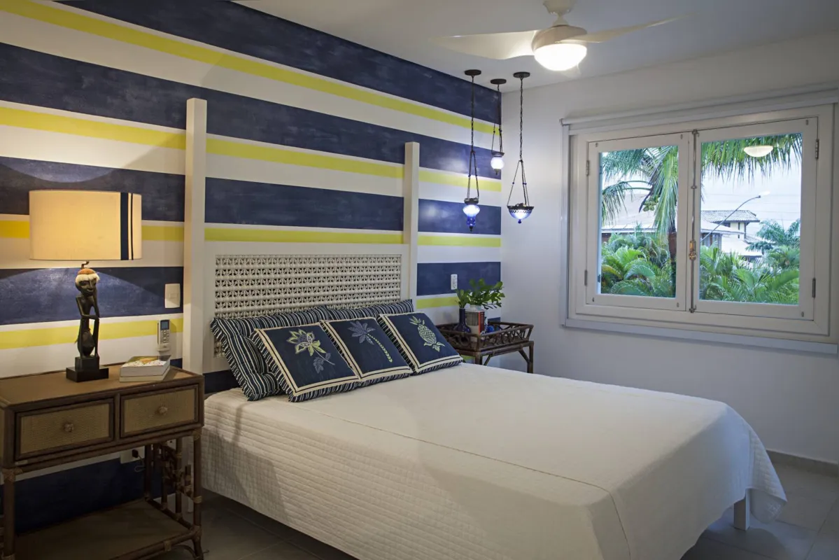 Exemplo perfeito da combinação do azul com outras cores. Amarelo foi eleito para compor uma das paredes do quarto, visando proporcionar aquela sensação maravilhosa de uma casa de veraneio