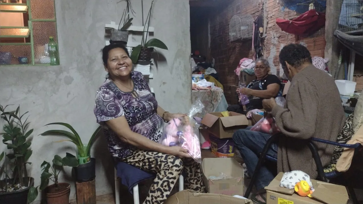 Os voluntários, Dejanira Marcolino Cordeiro, Maria Aparecida Cordeiro de Souza e Laércio Souza Costa preparam os presentes