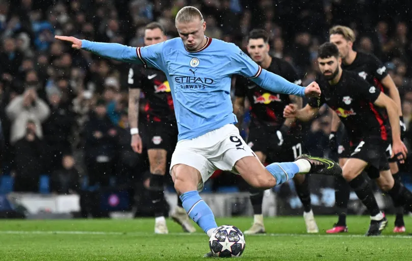 Manchester City's Norwegian striker Erling Haaland shoots from the penalty spot to score the team's  opening goal during the UEFA Champions League round of 16 second-leg football match between Manchester City and RB Leipzig at the Etihad Stadium in Manchester, north west England, on March 14, 2023. (Photo by Paul ELLIS / AFP)