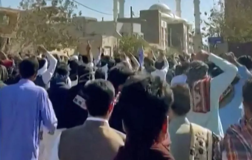 Manifestantes iranianos protestam em uma rua na cidade de Zahedan contra a morte de Mahsa Amini após sua prisão pela polícia moral em Teerã por supostamente descumprir o rígido código de vestimenta da república islâmica para mulheres