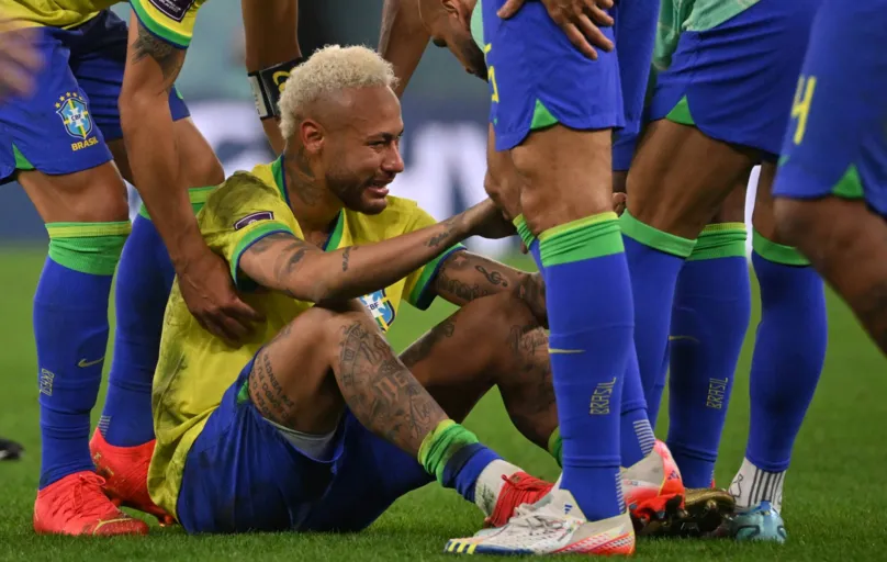 Brazil's forward #10 Neymar is consoled by teammates after they lost the Qatar 2022 World Cup quarter-final football match between Croatia and Brazil at Education City Stadium in Al-Rayyan, west of Doha, on December 9, 2022. (Photo by NELSON ALMEIDA / AFP)