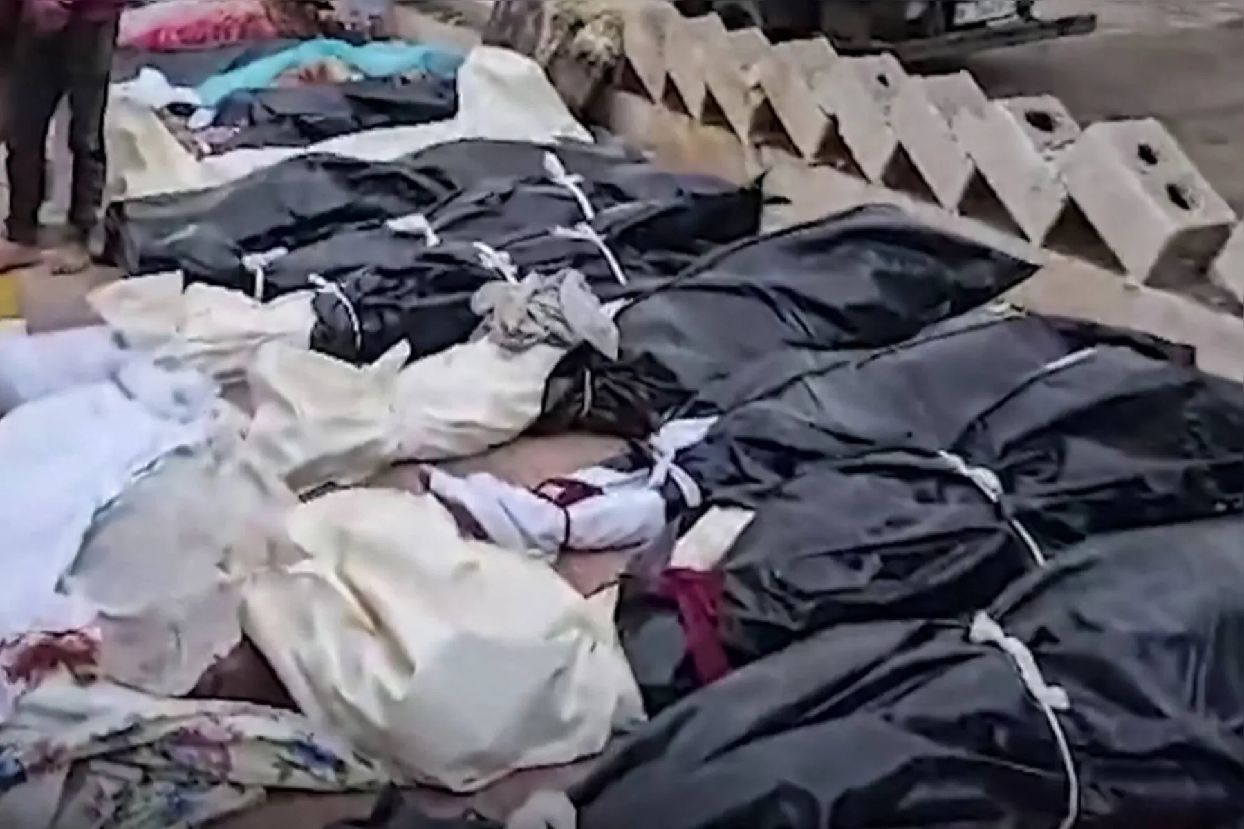 Dezenas de corpos cobertos por panos e lonas se acumularam  nas calçadas de Derna, após passagem da tempestade Daniel