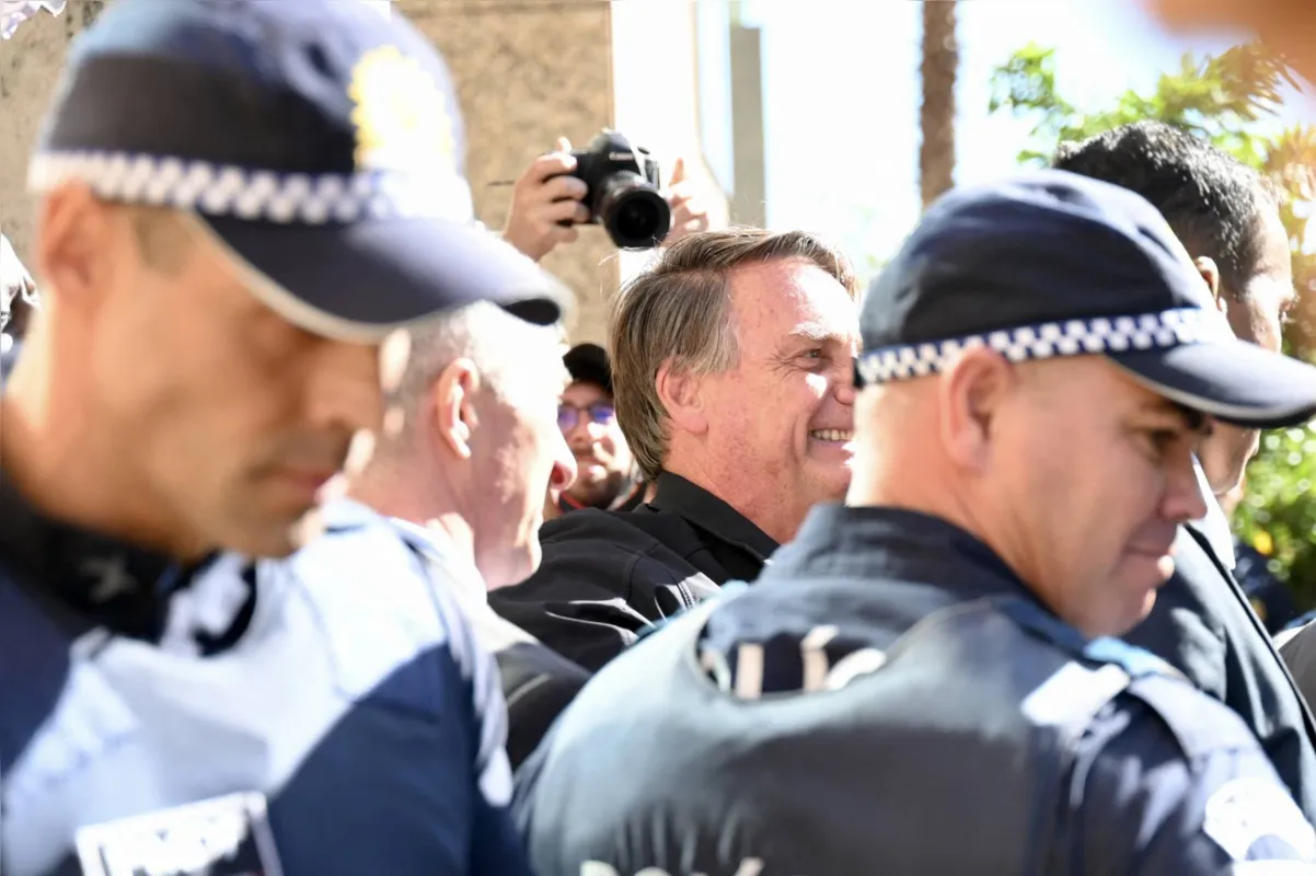 Former Brazilian president Jair Bolsonaro, surrounded by police officers, greets supporters at the Liberal Party headquarters in Brasilia on March 30, 2023. - Disconsolate over his "unjust" defeat in Brazil's divisive 2022 elections, Bolsonaro was uncharacteristically quiet when he slipped out of Brazil in the twilight of his presidential term for a self-imposed exile in Florida. (Photo by Evaristo Juliano DE SA and EVARISTO SA / AFP)