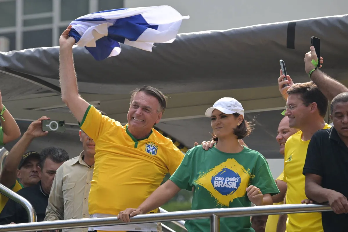 Bolsonaro acena ao público com uma bandeira de Israel, durante manifestação em São Paulo