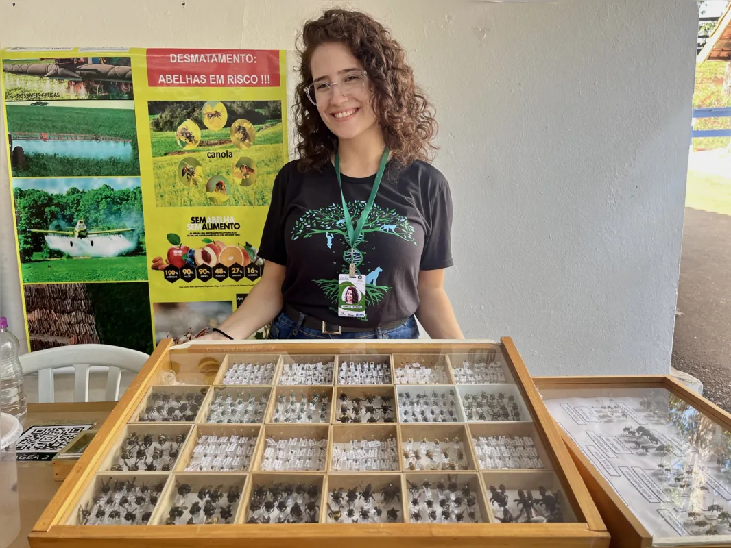 Isabela Toninato Tavares estuda em seu mestrado sobre um grupo específico de abelhas e, no estante, está compartilhando seus conhecimentos sobre estes insetos com os visitantes