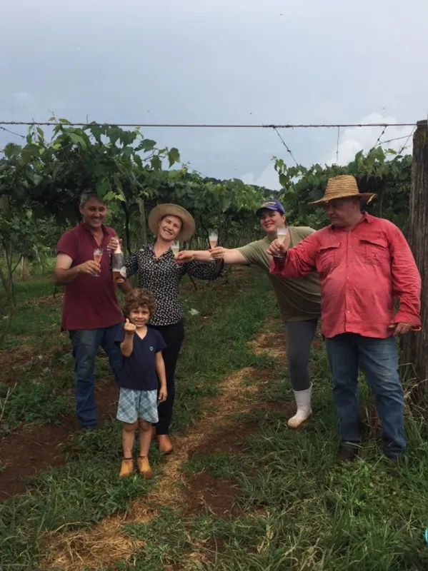 Cátia Betiatto brinda o final da colheita com familiares no parreiral, em Francisco Beltrão