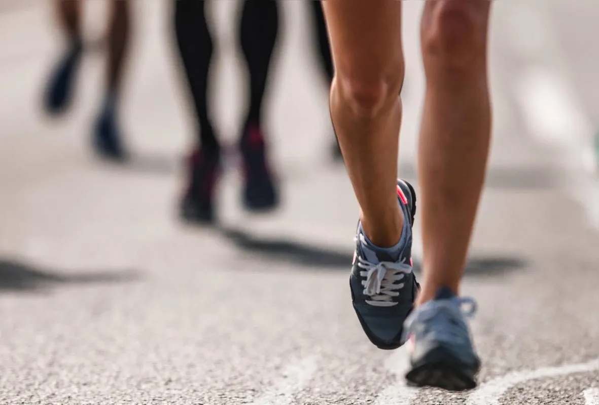 Unrecognizable marathon runner having a race on the road.