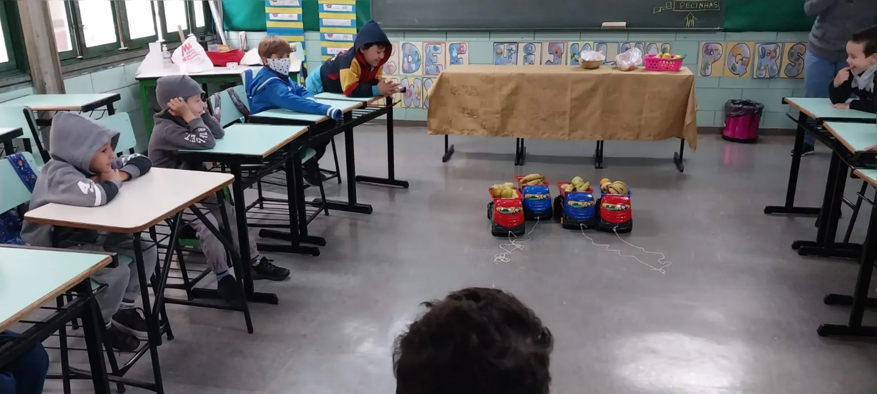 Na escola Municipal Mari Carrera Bueno, a simulação do transporte dos alimentos, em caminhões de brinquedo, integra o processo de alimentação