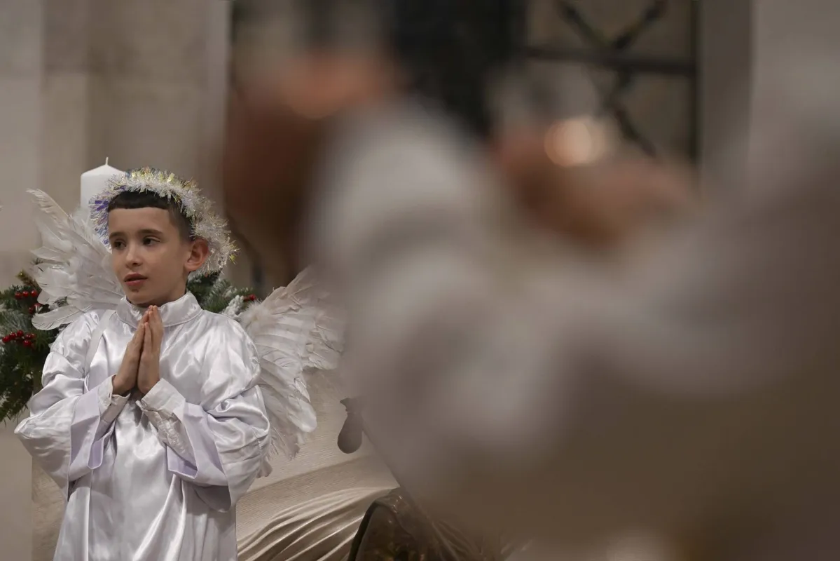Criança reza durante a missa na Catedral Madre Teresa em Pristina, em Kosovo