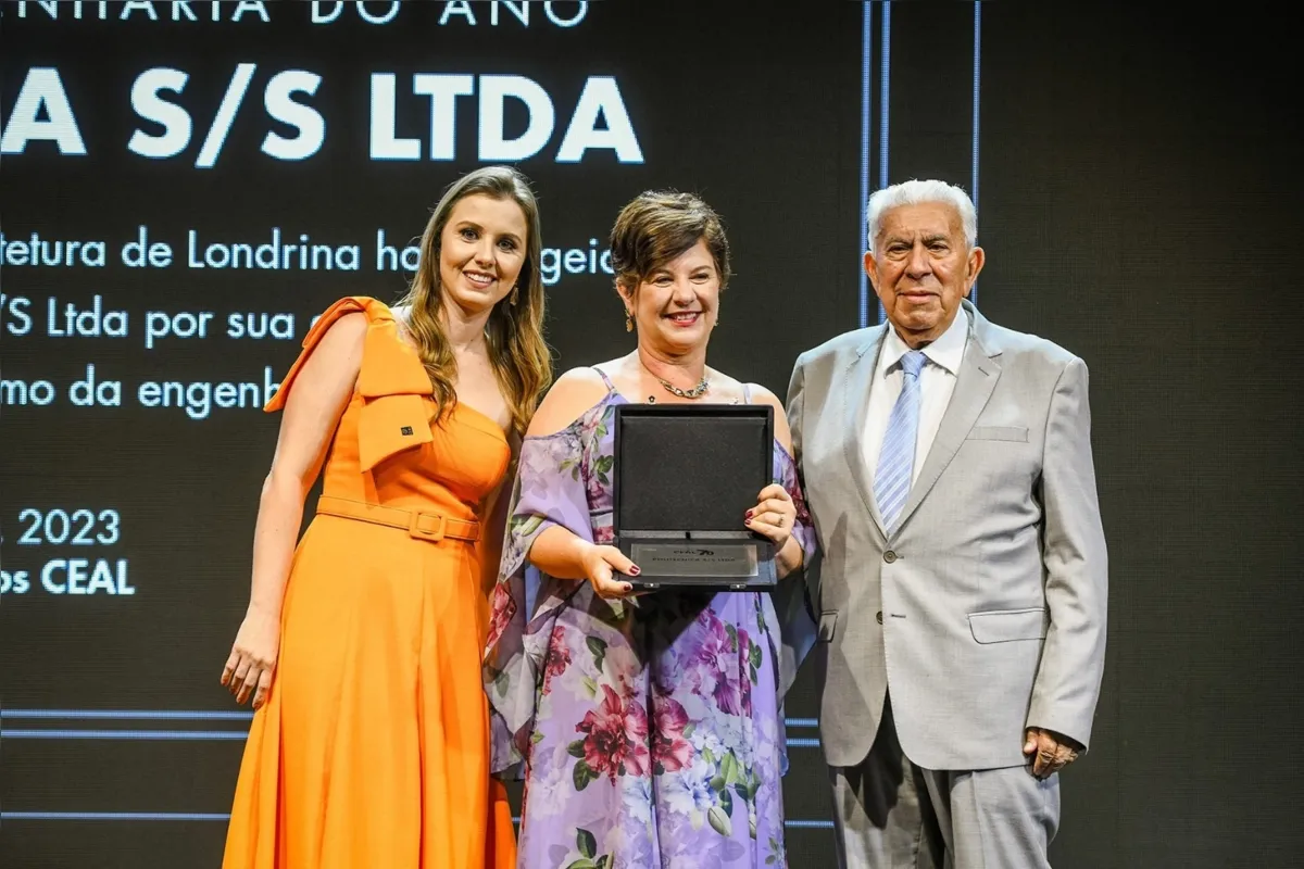 A engenheira civil (CEAL) Isadora Inocente (vestido laranja) entrega o prêmio aos engenheiros Elias Placido Vieira Cesar e Rebeka Ribas Cesar, da Politécnica Engenharia, considerada a empresa de engenharia do ano.