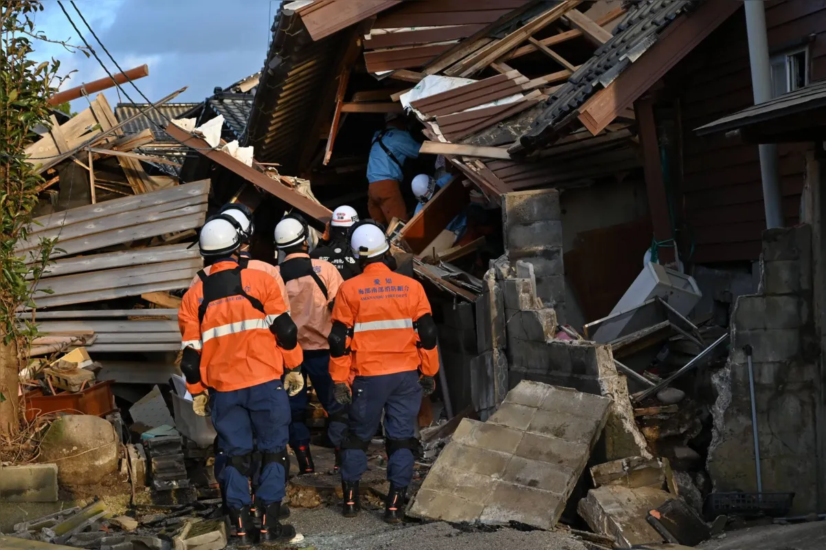 Bombeiros inspecionam casas de madeira desabadas em Wajima, província de Ishikawa, atingidas pelo terremoto que abalou o Japão no primeiro dia de 2024