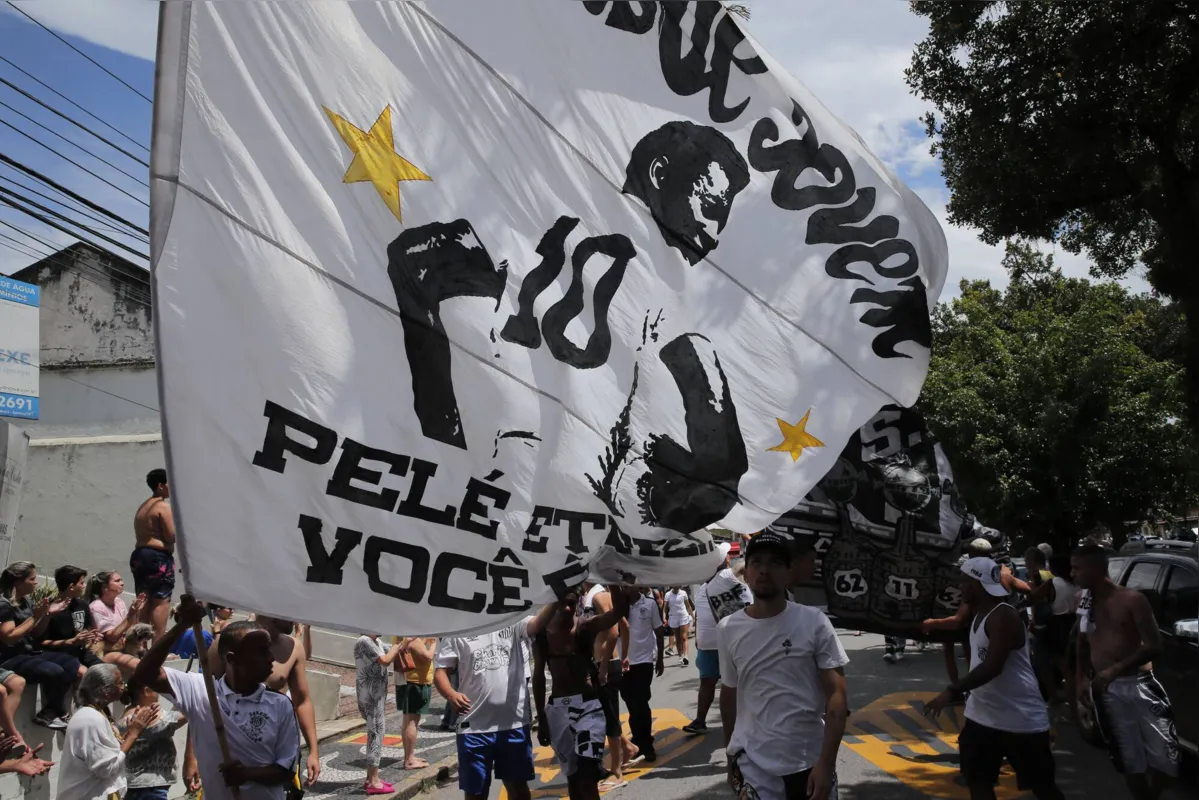 (FILES) Fans of the late Brazilian football star Pele gather on the street as a firetruck transports Pele's coffin to the Santos' Memorial Cemetery in Santos, Sao Paulo state, Brazil on January 3, 2023. Pele "would have been sad" at the state of the current Brazilian national team, his son Edinho has told AFP in an interview days before the first anniversary of his death on December 29, 2023. (Photo by CAIO GUATELLI / AFP)