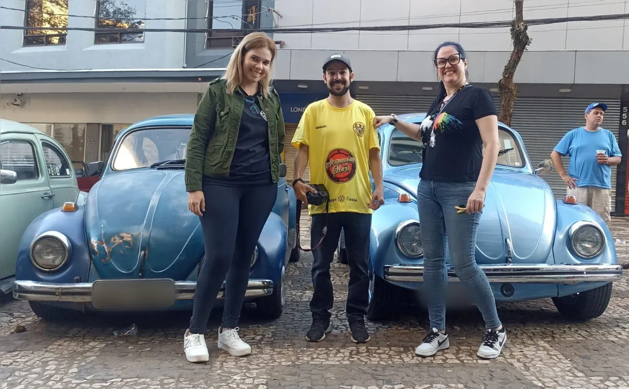 Querolaine, Marcus e Marina, ao lados de alguns exemplares dos famosos Fuscas azuis