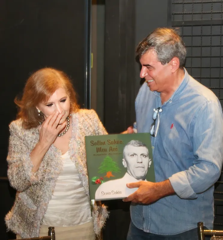 A anfitriã entrega o livro para o prefeito de Londrina