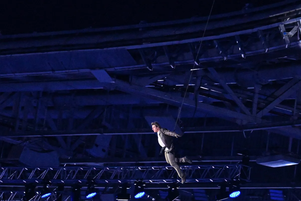 US' actor Tom Cruise descends from the roof of the stadium as part of the Los Angeles 2028 (LA28) handover ceremony during the closing ceremony of the Paris 2024 Olympic Games at the Stade de France, in Saint-Denis, in the outskirts of Paris, on August 11, 2024. (Photo by MOHD RASFAN / AFP)