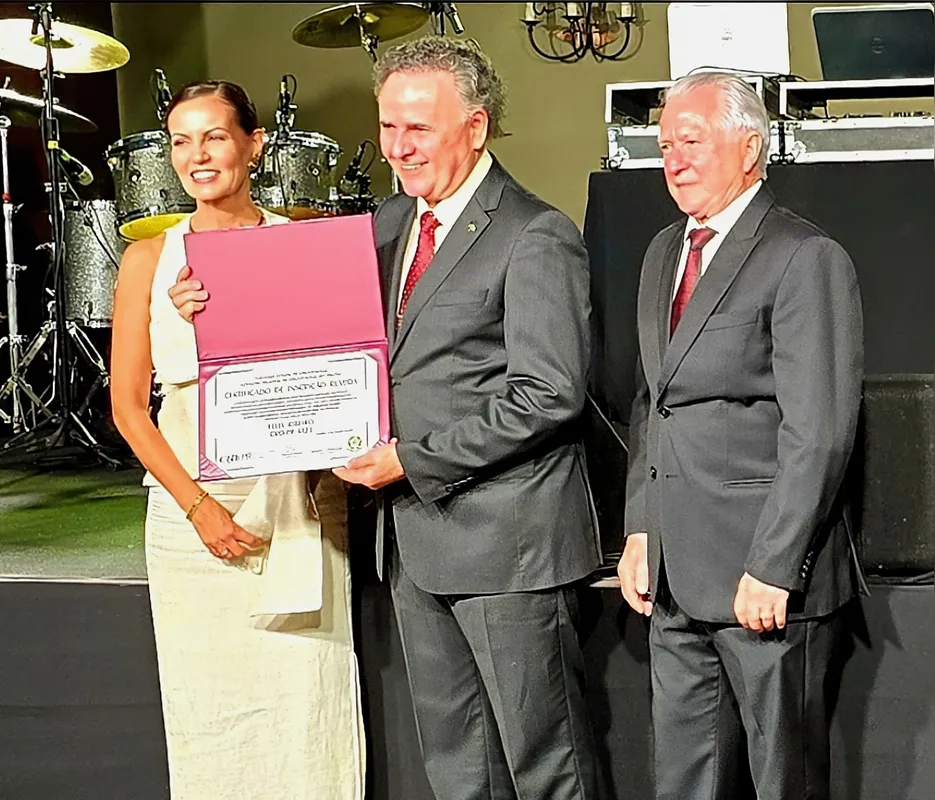 Dr. Félix Ribeiro recebendo o título de Inscrição Remida do Conselho Federal de Odontologia, dos diretores do CRO-PR, Dr. Claudenir Rossato e Dra. Cássia Garbelini.