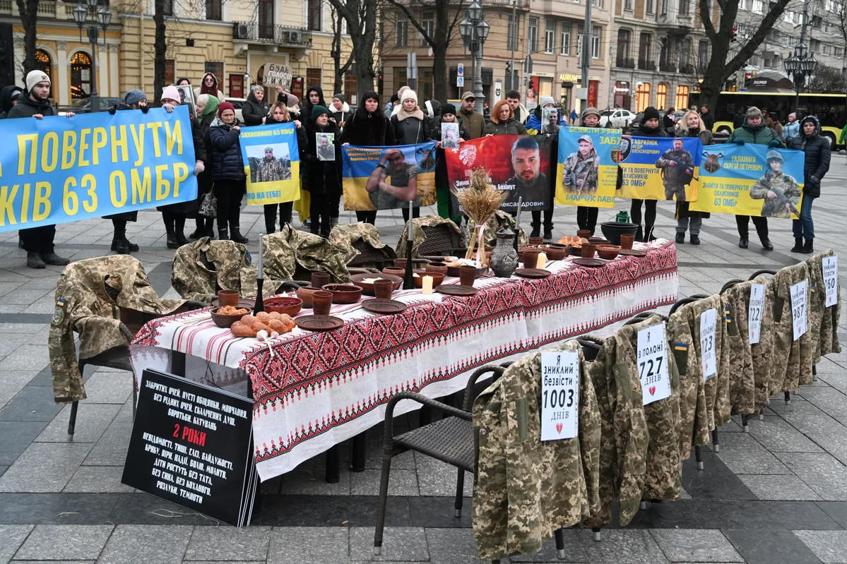 Uniformes de soldados pendurados em cadeiras vazias ao lado de uma mesa simbólica de Natal, durante ato em apoio aos prisioneiros de guerra e soldados desaparecidos em Lviv ,. em meio à invasão russa da Ucrânia