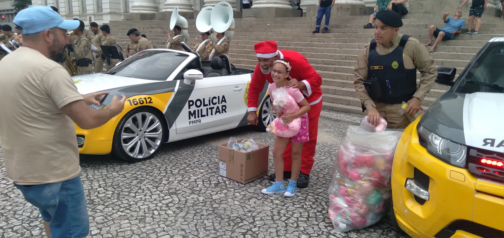 Com direito a banda da PMPR, Policiais Militares, através da AVM (Associação da Vila Militar), houve entrega de presentes para crianças na praça Santos Andrade, centro de Curitiba.

Célio Borba (Curitiba)