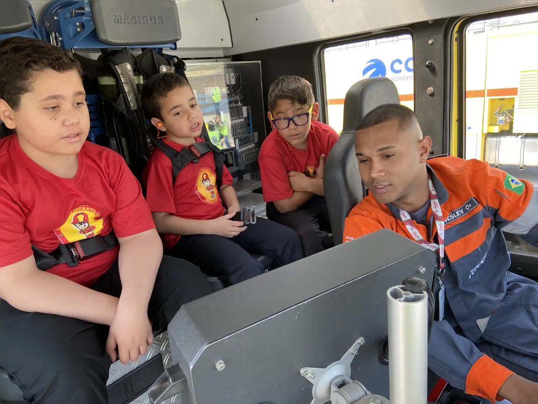 Lucas, Davi e Lucas na cabine com o bombeiro motorista Wesley Neves