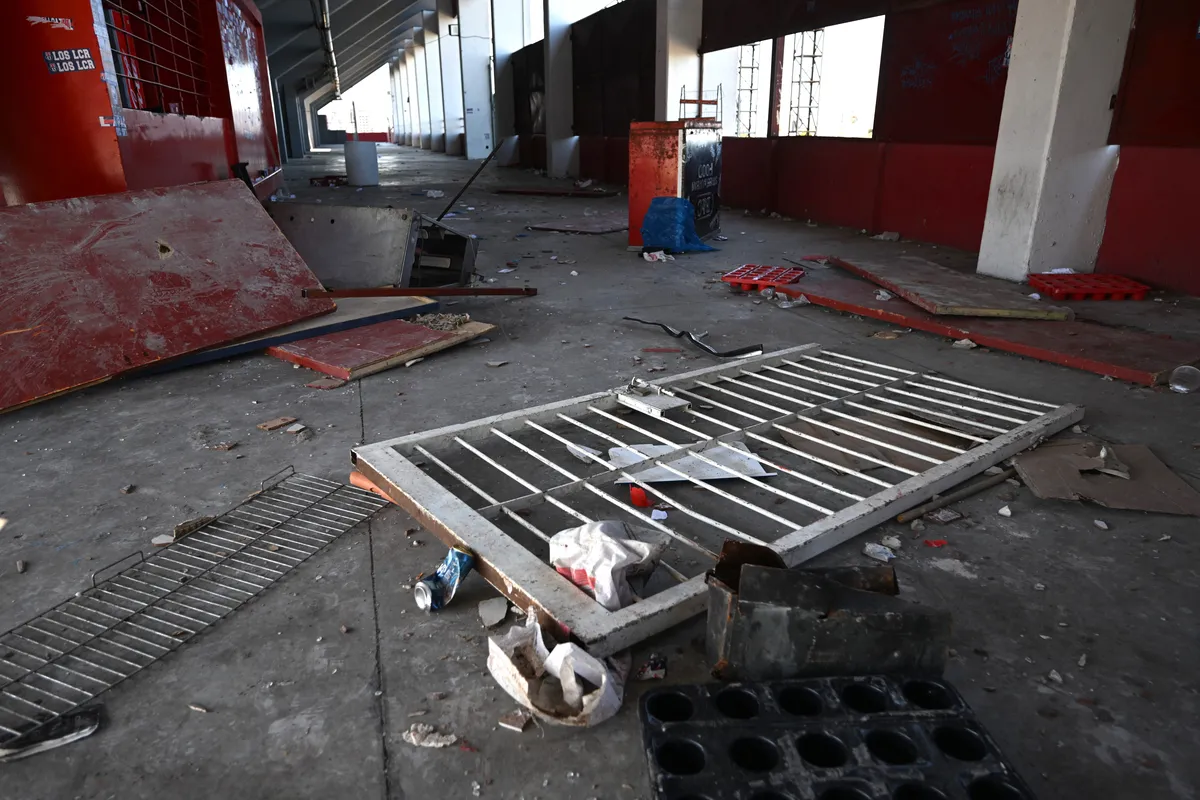 View of a broken gate of the Libertadores de America stadium in Avellaneda, Buenos Aires province, on August 21, 2025, after a Copa Sudamericana football match between Independiente and visiting Universidad de Chile was abandoned following sustained crowd violence. More than 100 football fans were in custody Thursday after Argentine and Chilean supporters fought with knives, sticks, stun grenades, and bathroom fittings during a club knock-out match near Buenos Aires. (Photo by Luis ROBAYO / AFP)