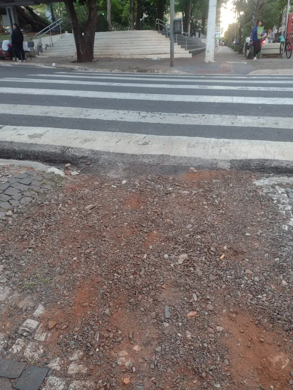 Trecho do Calçadão com avenida Rio de Janeiro apresenta rampa danificada e cheia de pedregulhos, dificultando a passagem de pedestres e cadeirantes