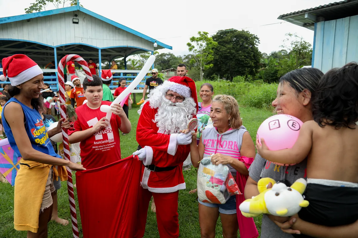 O voluntário Jorge Alberto Barrozo, dressed entrega presentes às famílias da comunidade rural de Careiro da Varzea, Amazonas. Desde 1998, o grupo de voluntários promove o Natal nesta localidade