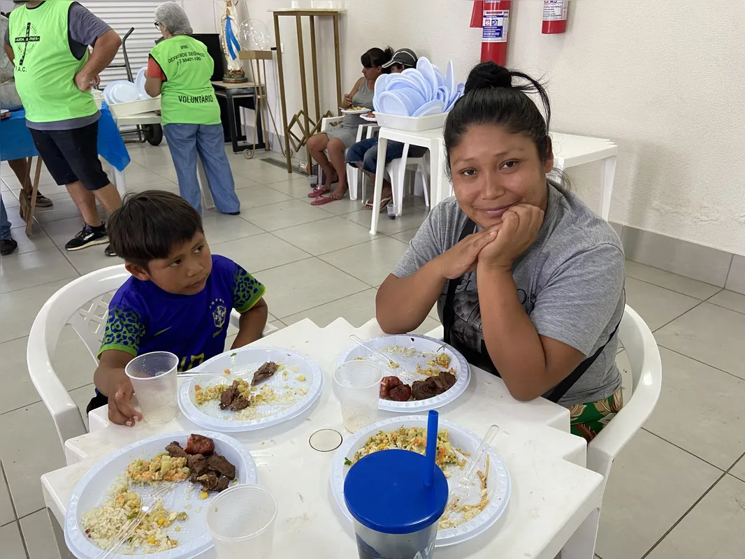 Edna Vergílio e seu primo José Felipe almoçando a comida preparada pelos voluntários
