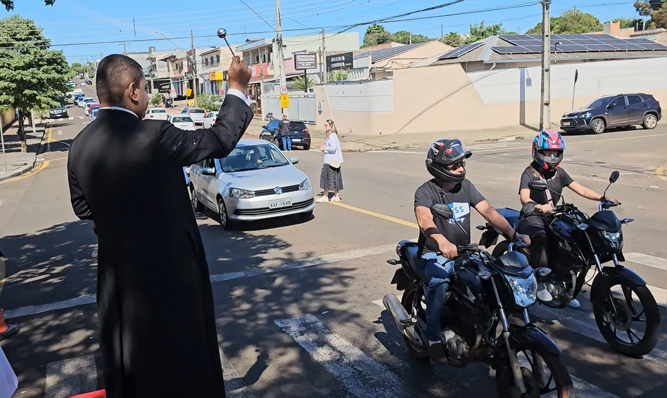 Padre Dirceu Júnior dos Reis abençoando veículos durante a carreata