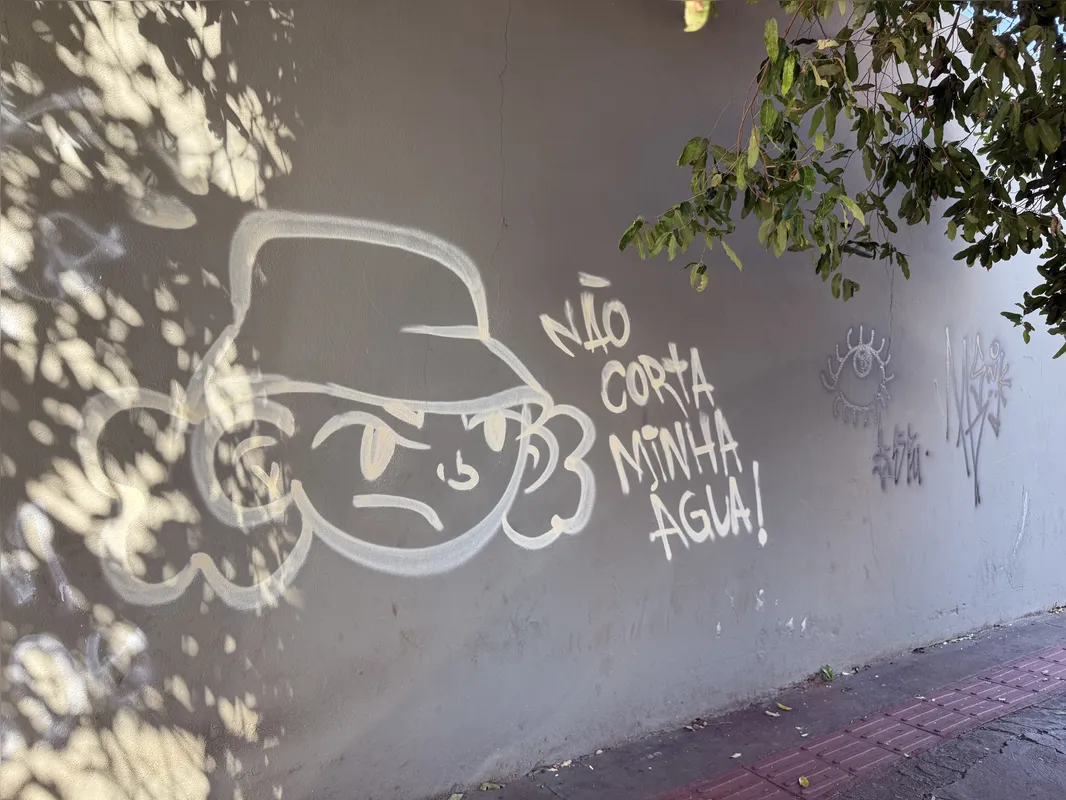 Parede de um prédio da Sanepar, na região central, foi pichada com um desenho e ordem: "não corta minha água!"