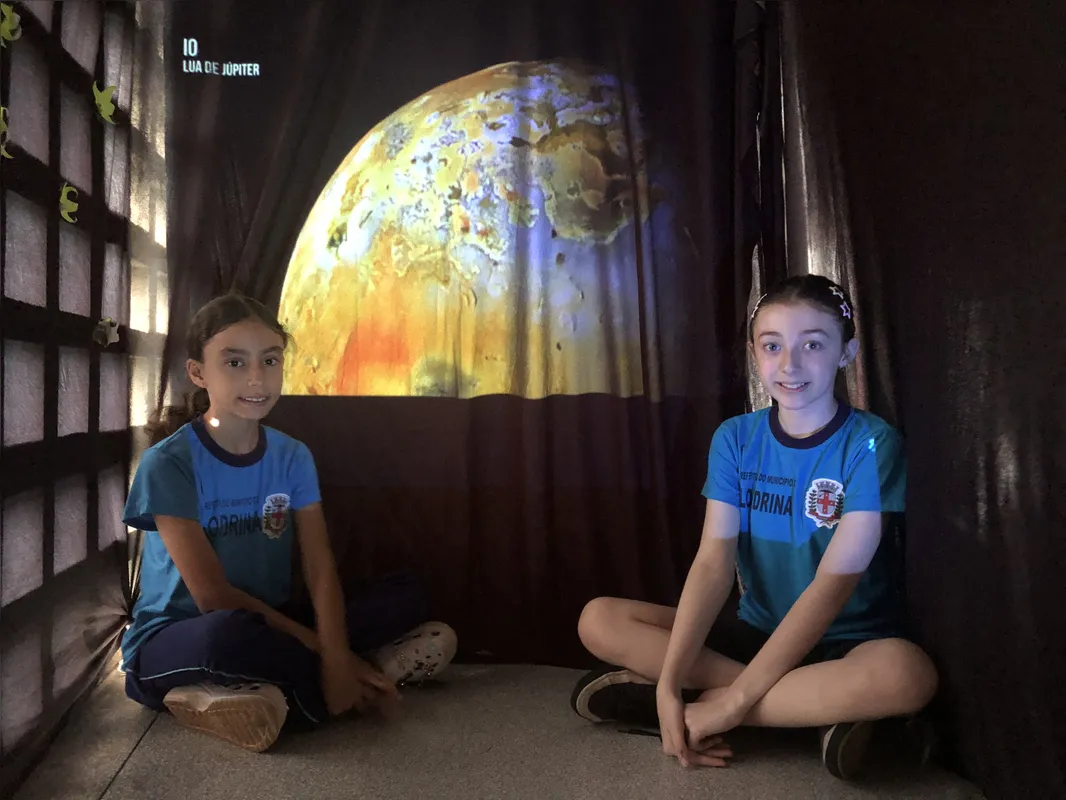 L,ívia Francielle Catarino e Helena de Lima Merlin que criaram uma sala de projeção, com elemntos da astronomia, para lembrar o livro "Extraordinário", de R.J. Palacio