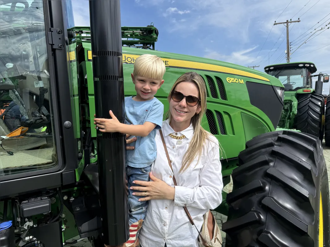 Rebeca Venturelli e o filho José em um dos estandes de maquínas agrícolas