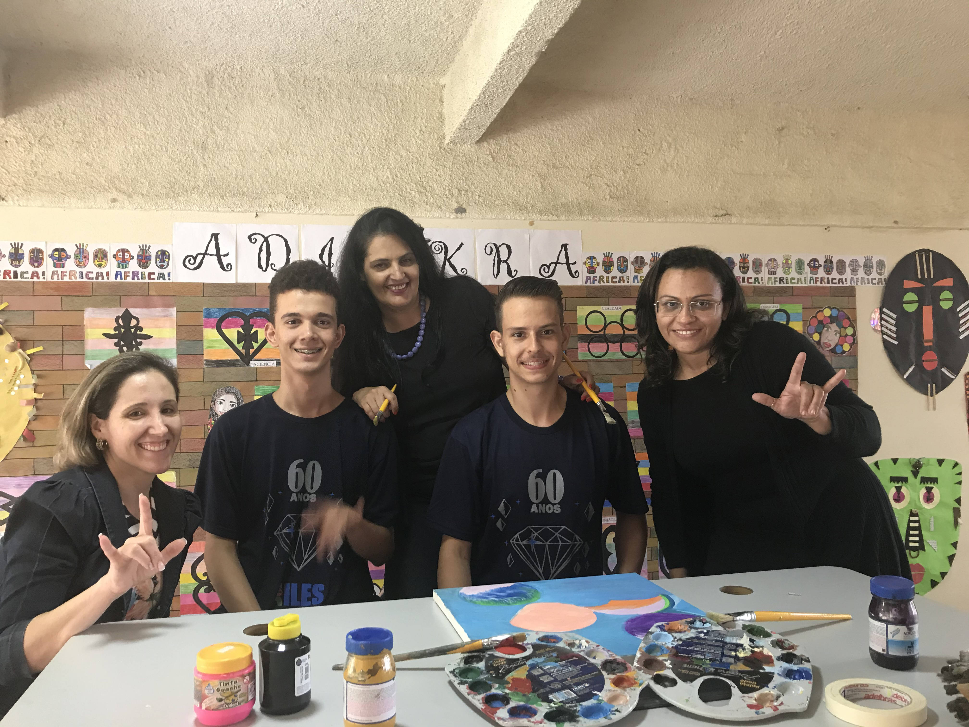 As professoras Elizângela, Simone e Rita com os alunos: em libras o gesto com as mãos significa "Eu te amo do jeito que você é"