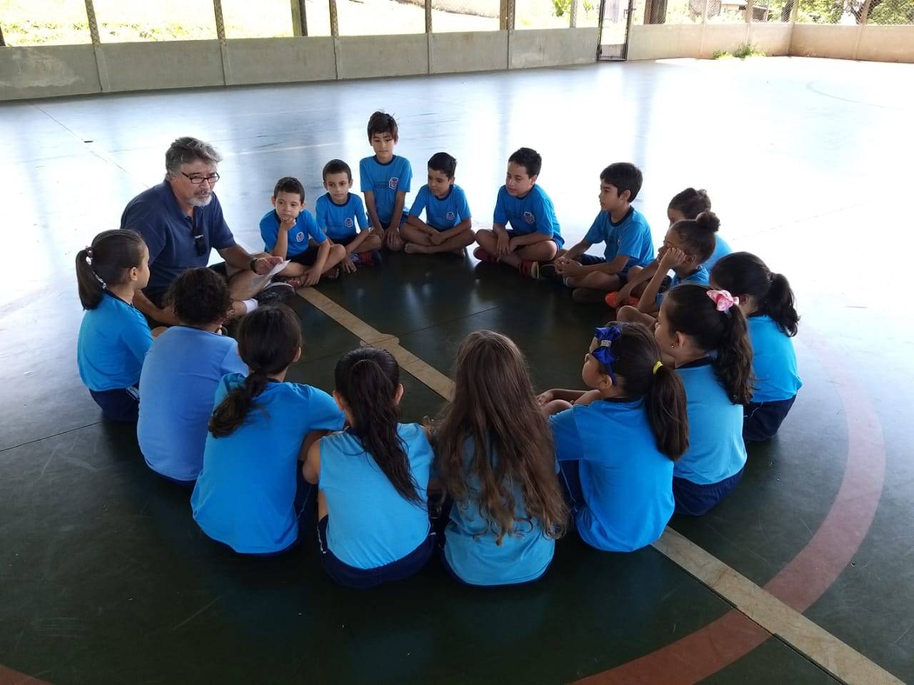 Professor de Educação Física Marco Antonio Cabral Ferreira na roda com alunos da Escola Municipal Odésio Franciscon
